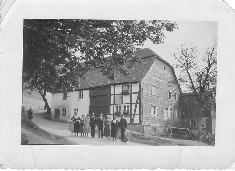 Historisches Familienfoto vor einem alten Fachwerkhaus – Ahnenforschung und Familiengeschichte entdecken